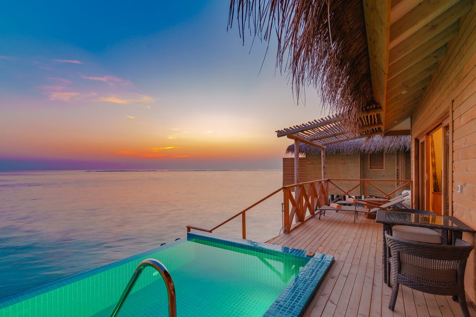 Peaceful overwater villa with private pool at sunset in the Maldives.