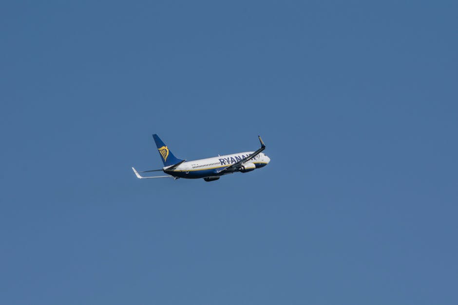 A Ryanair Boeing 737 flying high in the clear blue sky above Wrocław, Poland.