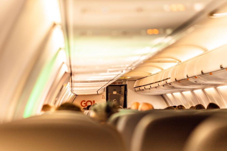 Interior of a commercial airplane with passengers blurred inside the cabin, showcasing travel atmosphere.