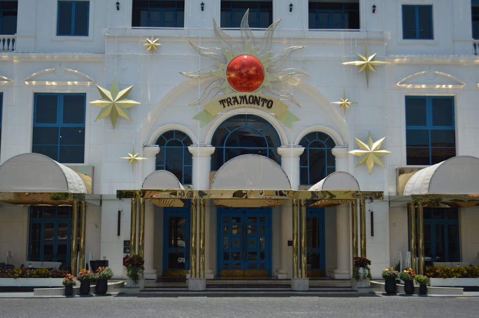 Elegant entrance of Tramonto Hotel featuring sun-themed decorations and vibrant blue doors.