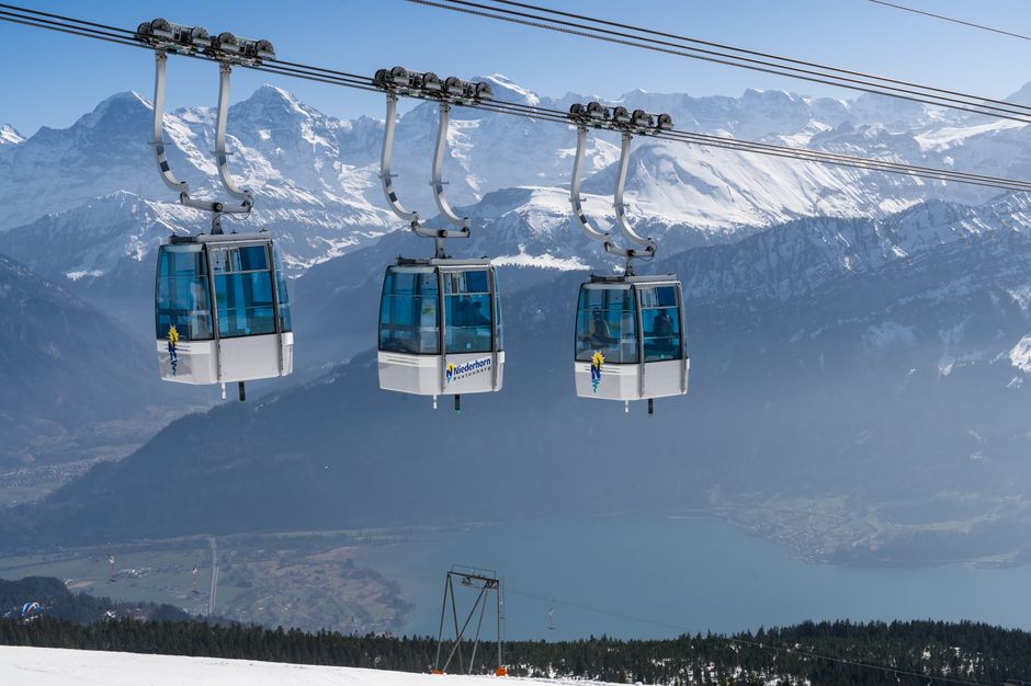 Cable cars overlooking the scenic Swiss Alps with clear blue skies.