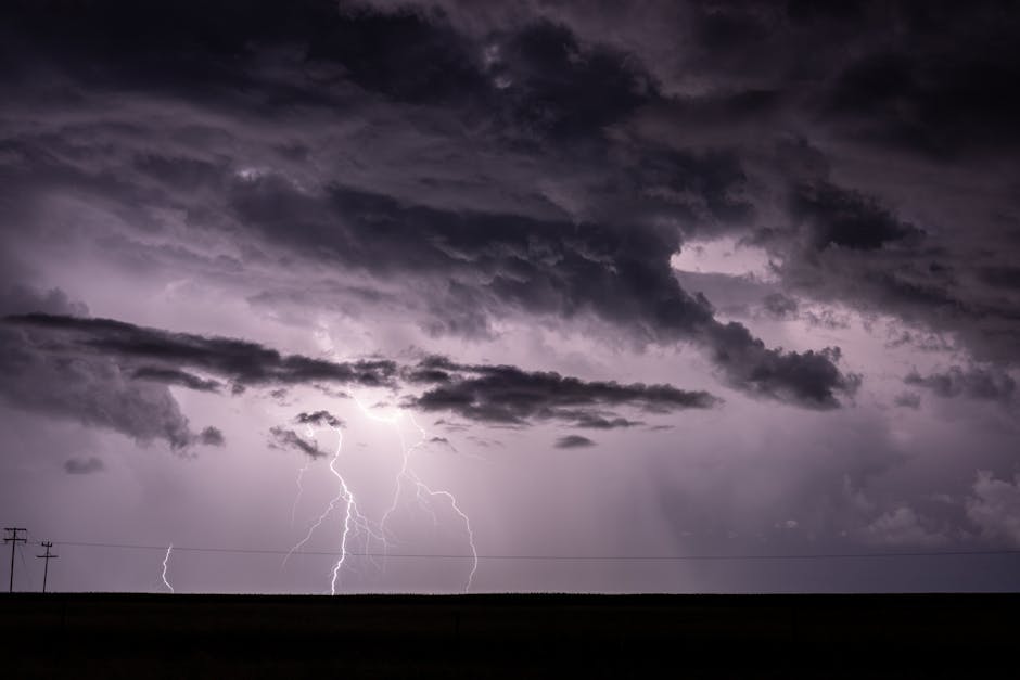 Dramatic stormy sky with intense lightning strikes illuminating dark clouds.