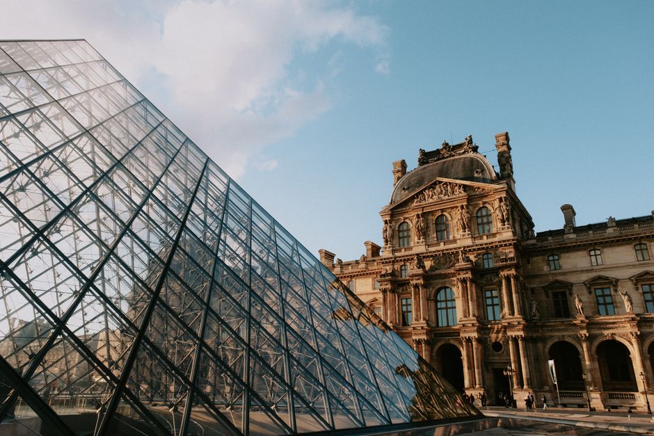 Stunning view of the Louvre Pyramid and historical museum architecture in Paris.